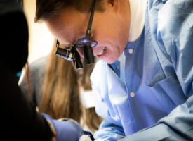 Surgeon using surgical microscope during operation.