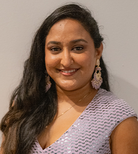 Here's an alt tag for the image: Smiling woman with long dark hair.